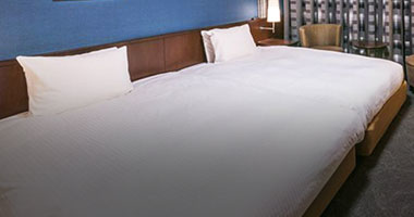 画像：清潔感を重視したデュベスタイルのベッド