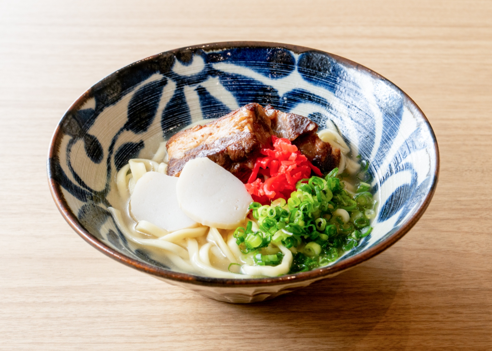 【沖縄そば】<br>そば粉ではなく,小麦粉を使った太めの麺と、豚骨とかつお節からとるブレンドのだしで仕上げたスープが特徴。<br>紅ショウガなどトッピングはお好みで♪
